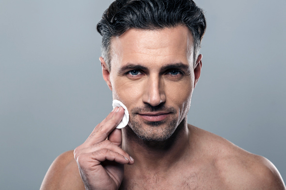 man applying skincare with cotton pad with a focus on 2 step skincare routine