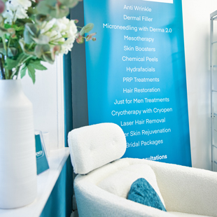 interior of a beauty clinic featuring a comfortable white chair and a decorative vase with flowers alongside a banner listing various skin treatments including anti wrinkle and skin rejuvenation options also mentioning different services offered for men and cosmetic procedures related to 9 aesthetic solutions